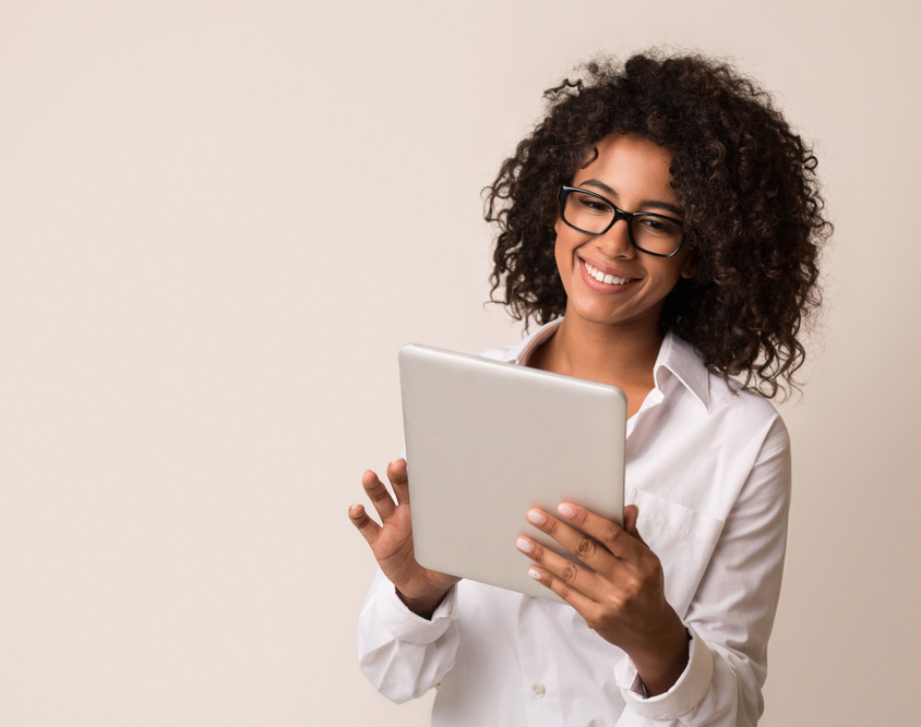 Eine junge Frau wischt über das Tablet in ihrer Hand.