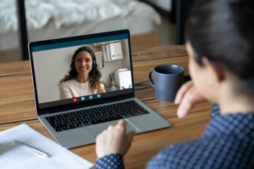 Eine Lehrerin und eine Mutter unterhalten sich per Videokonferenz.