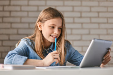 Eine Schülerin arbeitet mit ihrem Tablet.