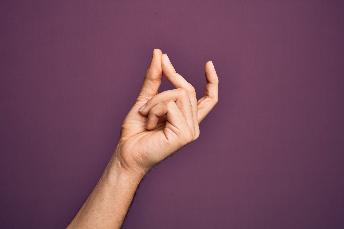 Das Bild zeigt eine mit den Fingern schnippende Hand vor einem violetten Hintergrund.